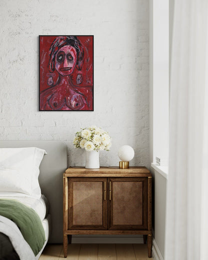 Red abstract painting on a wall above a wooden side table with a lamp and flowers.