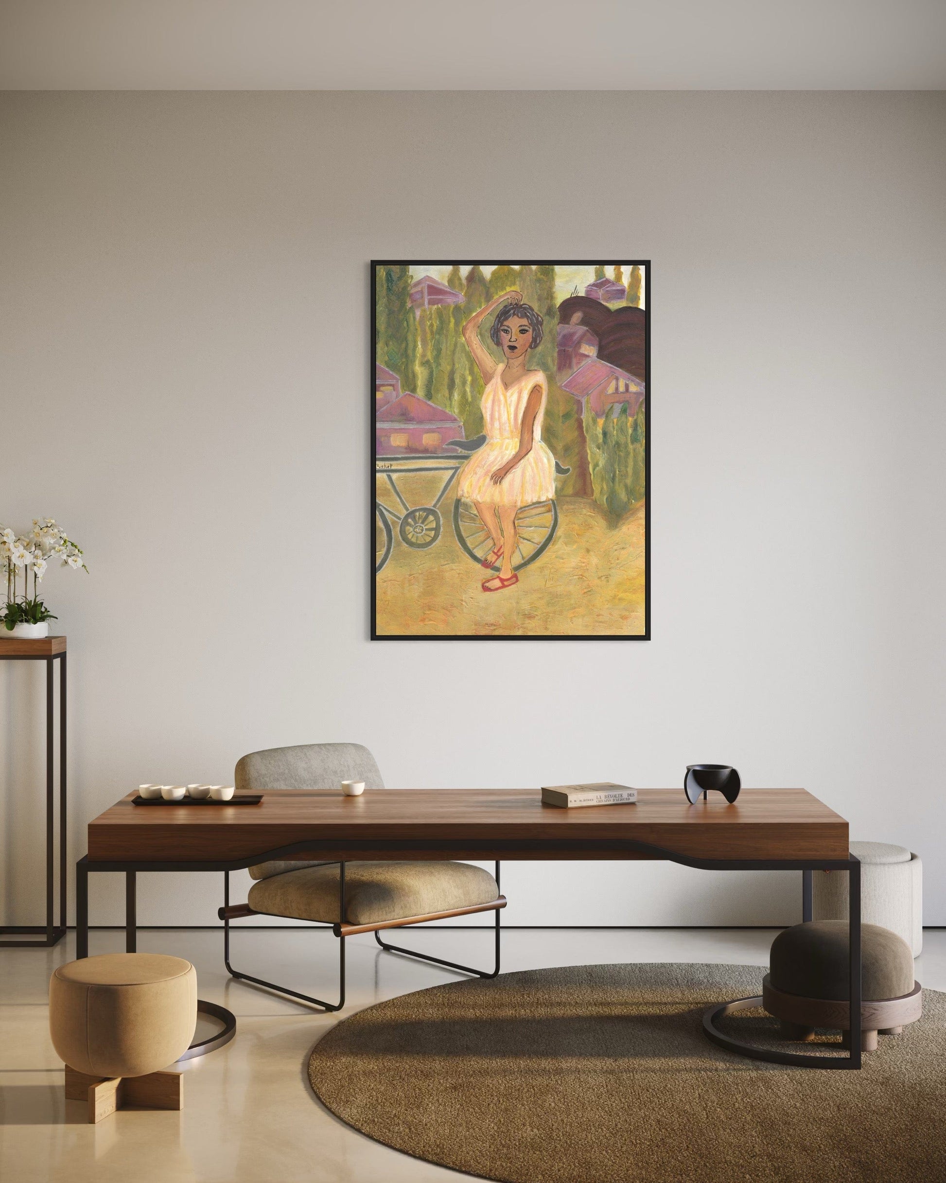 Framed artwork of a woman with flowers in a room with a wooden desk and chairs.