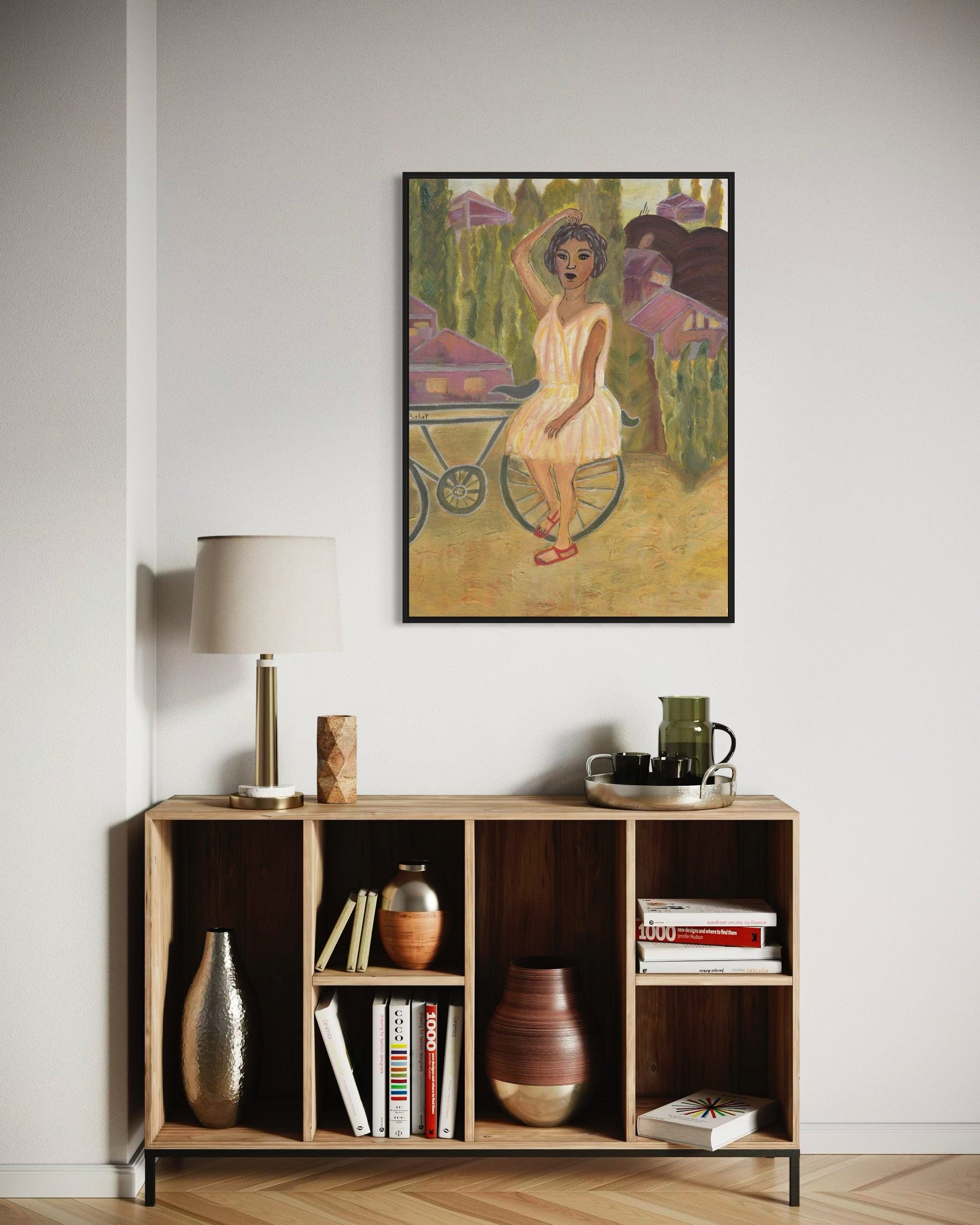 Framed artwork of a woman in a garden above a wooden sideboard with decorative items.