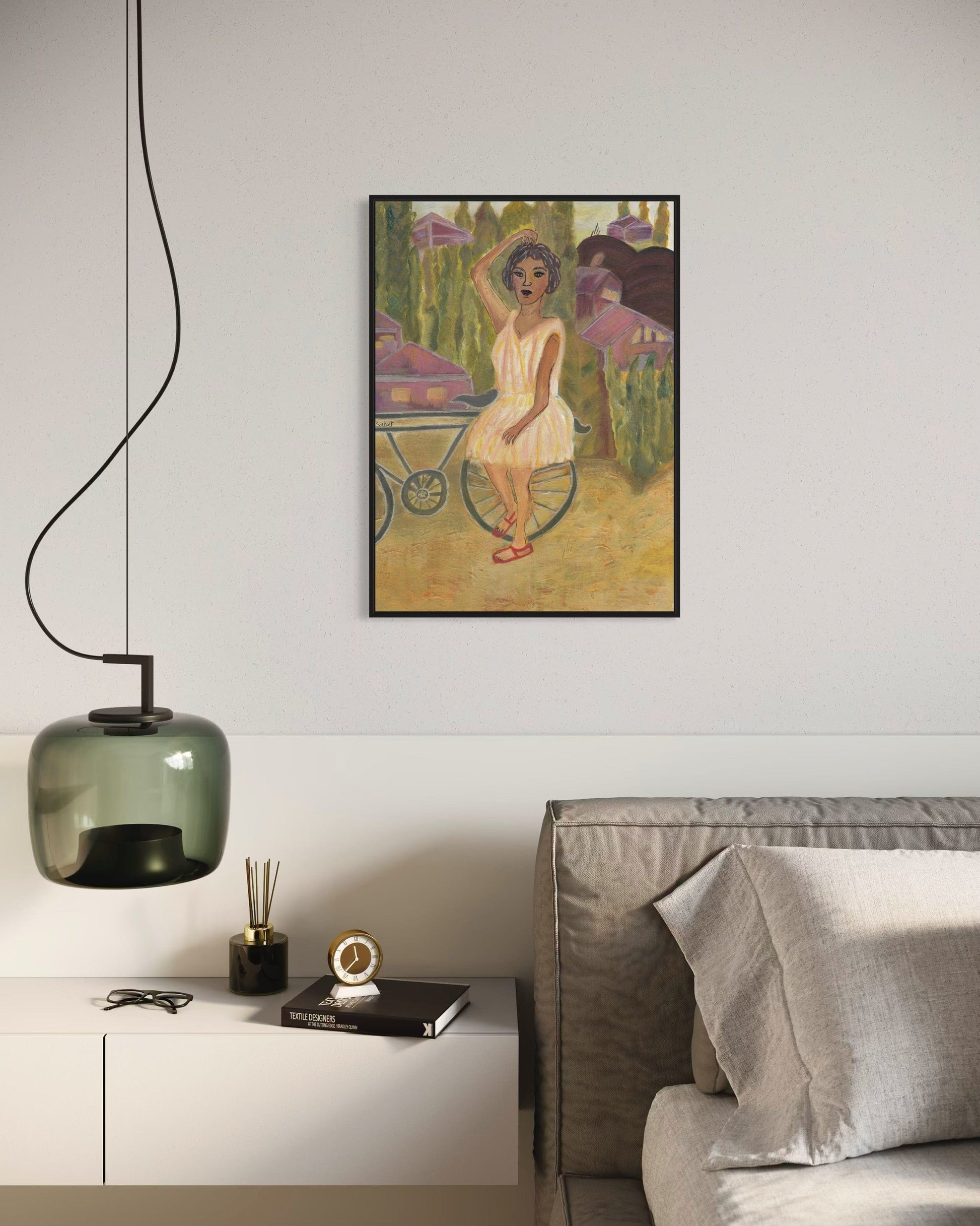Framed artwork of a woman with a bicycle on a wall above a modern living room setup.