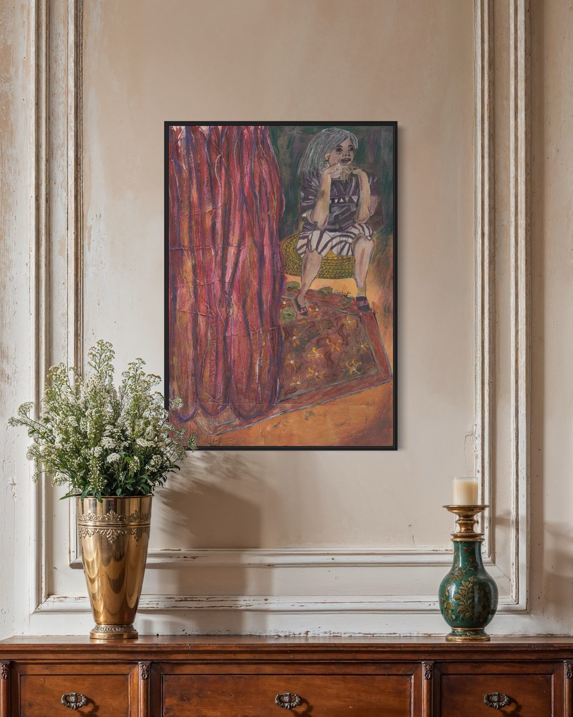 Framed artwork on a wall above a wooden console table with decorative items.