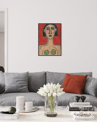 Framed artwork on a wall above a gray sofa with decorative items.