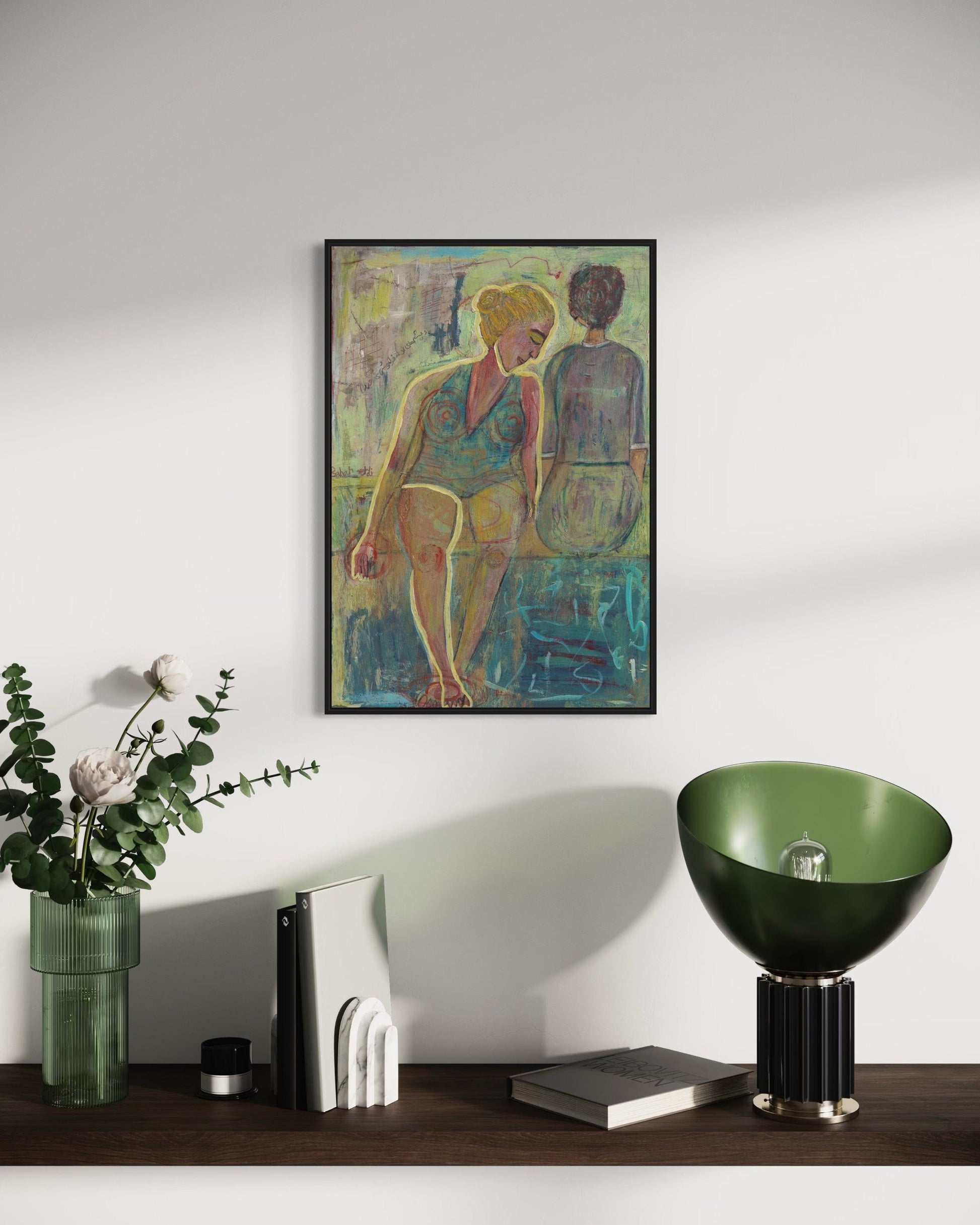 Framed artwork on a wall with decorative items on a shelf below.