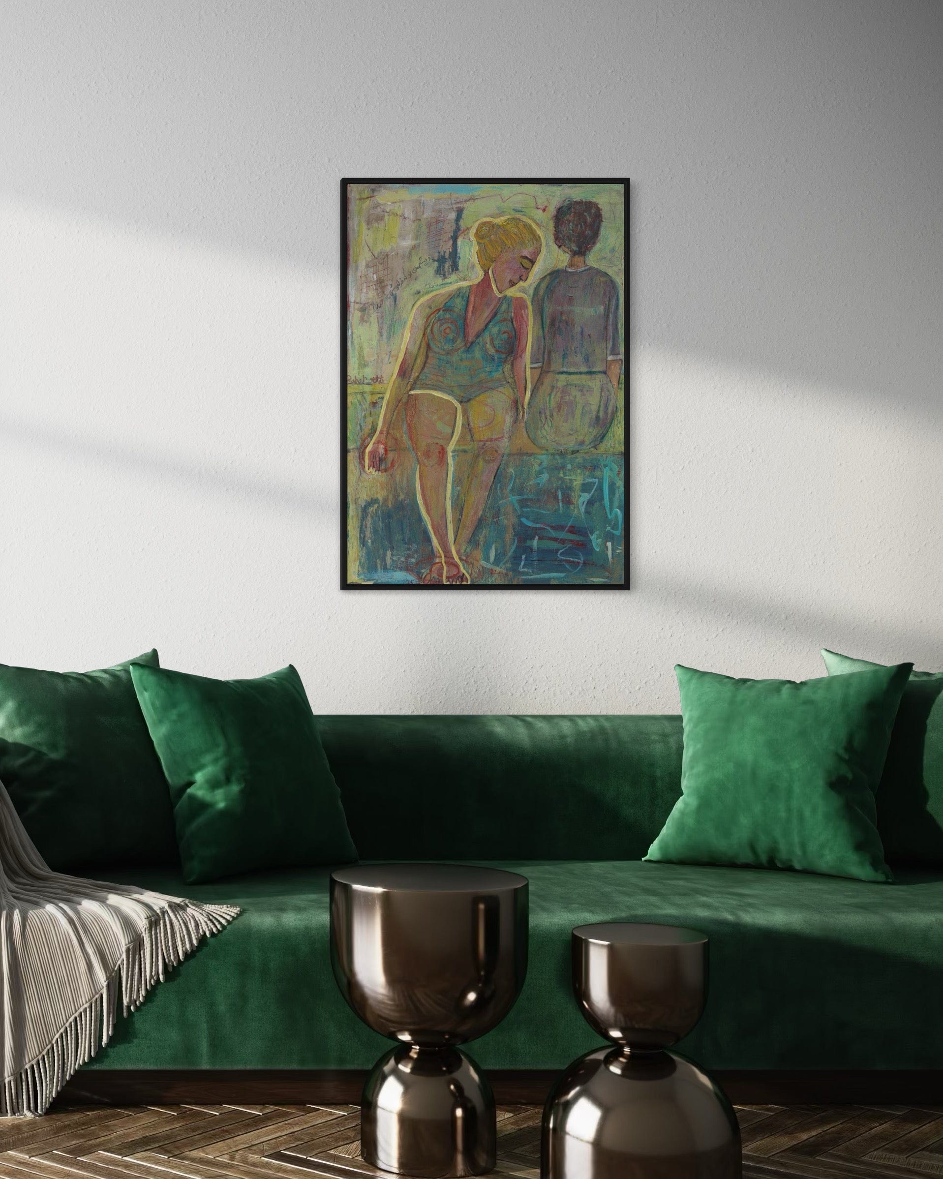 Green sofa with decorative pillows and a framed artwork on the wall in a living room setting.