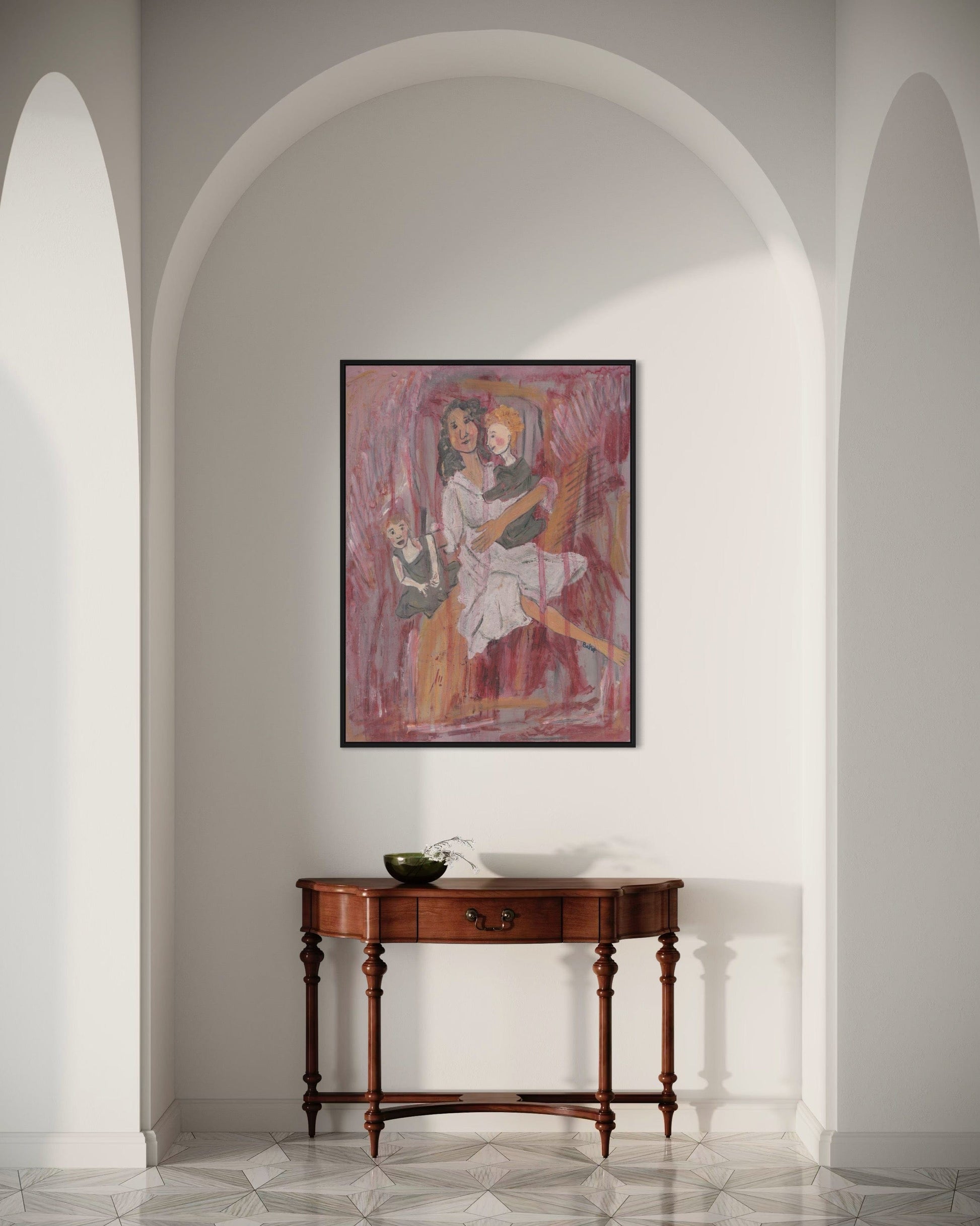 Framed artwork on a wall above a wooden console table in a room with arched doorways.