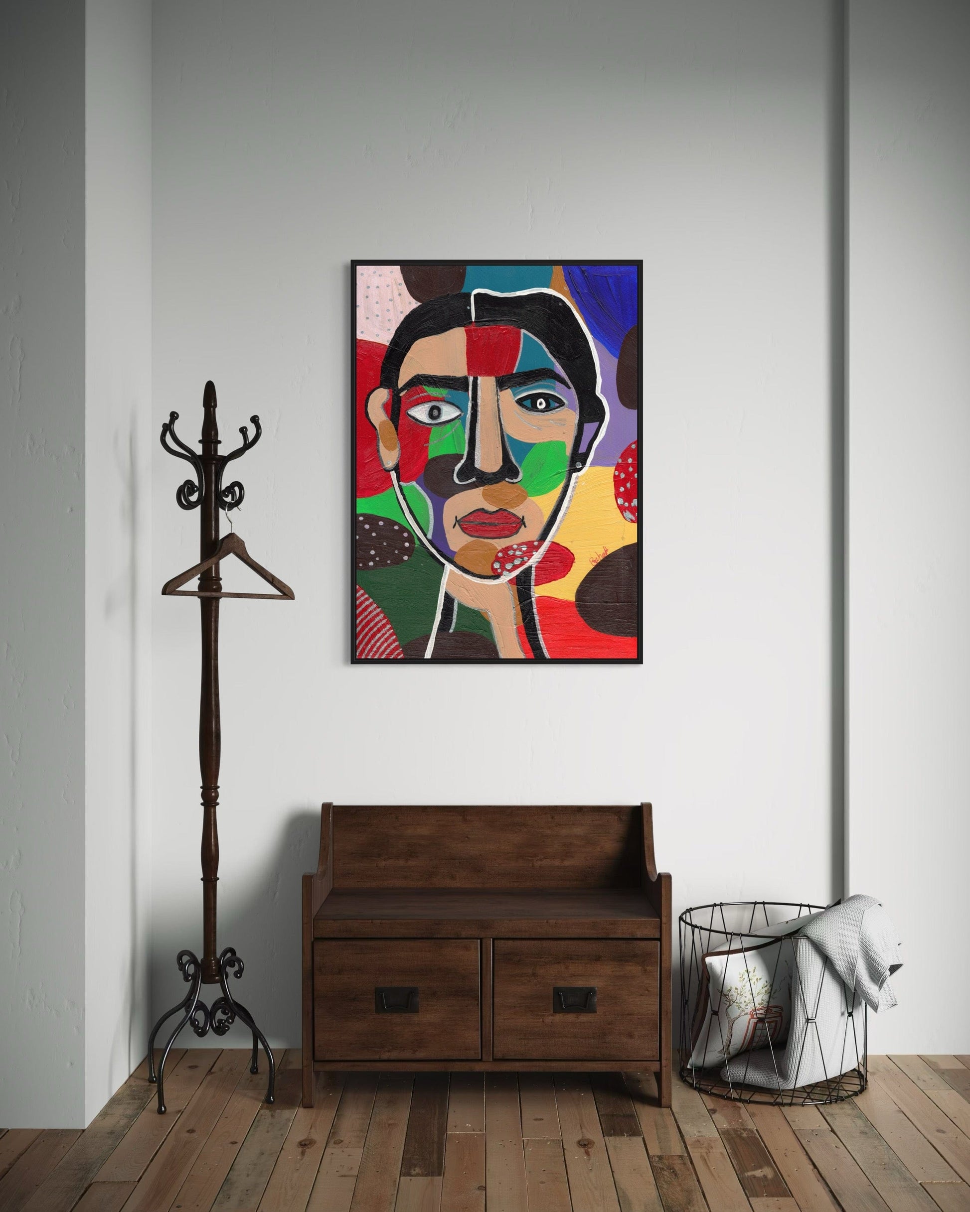 Colorful abstract painting on a wall above a wooden bench with a coat rack and trash can in the foreground.