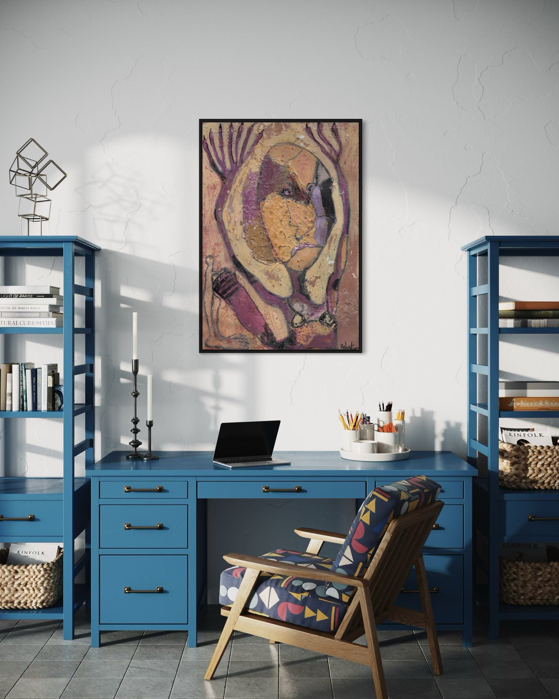 Home office with blue desk, chair, and bookshelves with a colorful abstract painting on the wall.