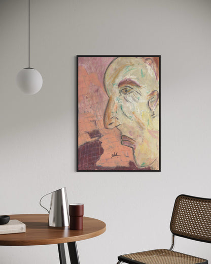 Framed abstract art on a wall above a table with a chair and lamp.