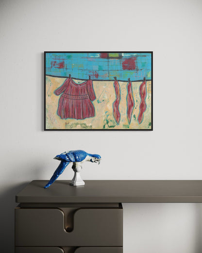 Framed abstract artwork on a wall above a desk with a decorative object.