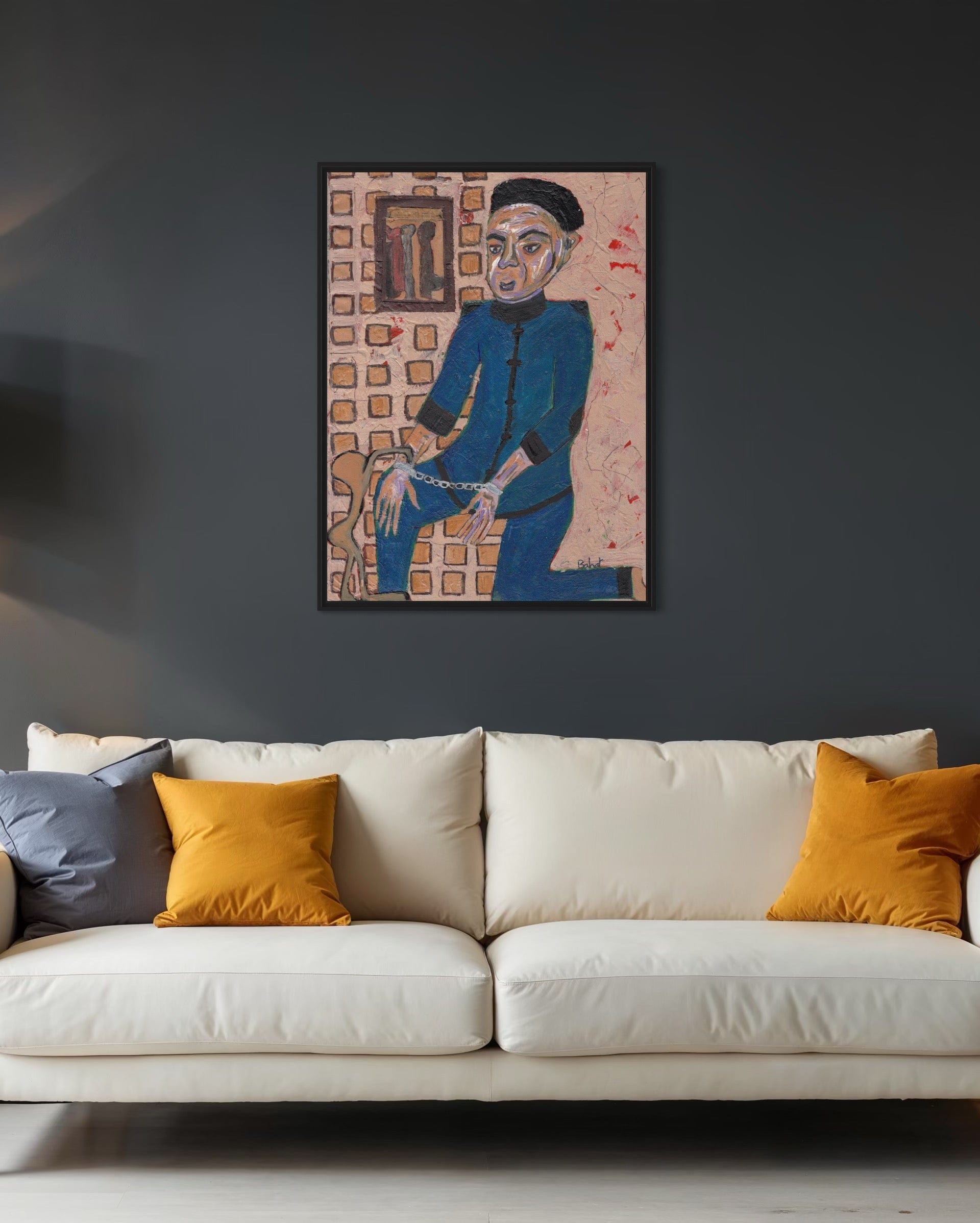 Framed artwork on a dark wall above a white sofa with orange and gray cushions.