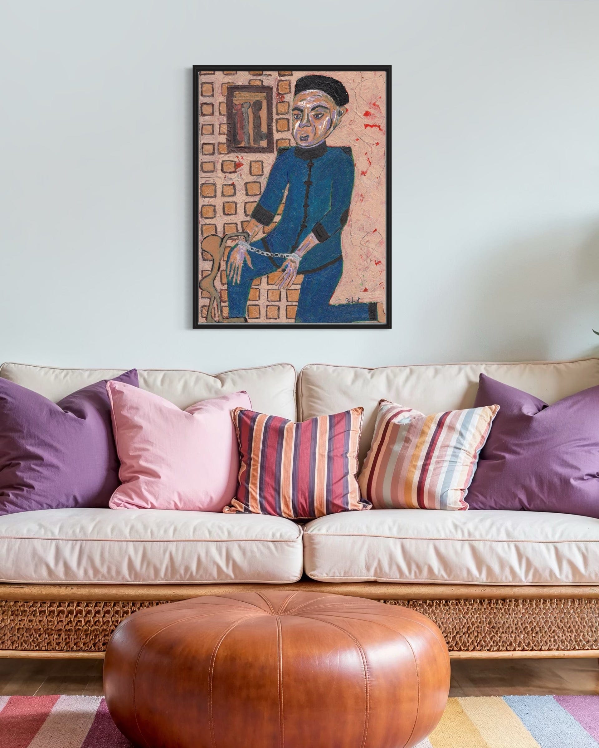Beige sofa with colorful pillows and a framed artwork on the wall.