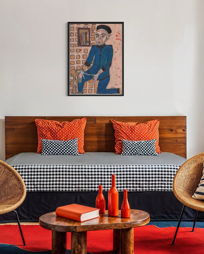 Modern bedroom with wooden bed, orange and black pillows, and decorative items on a small table.