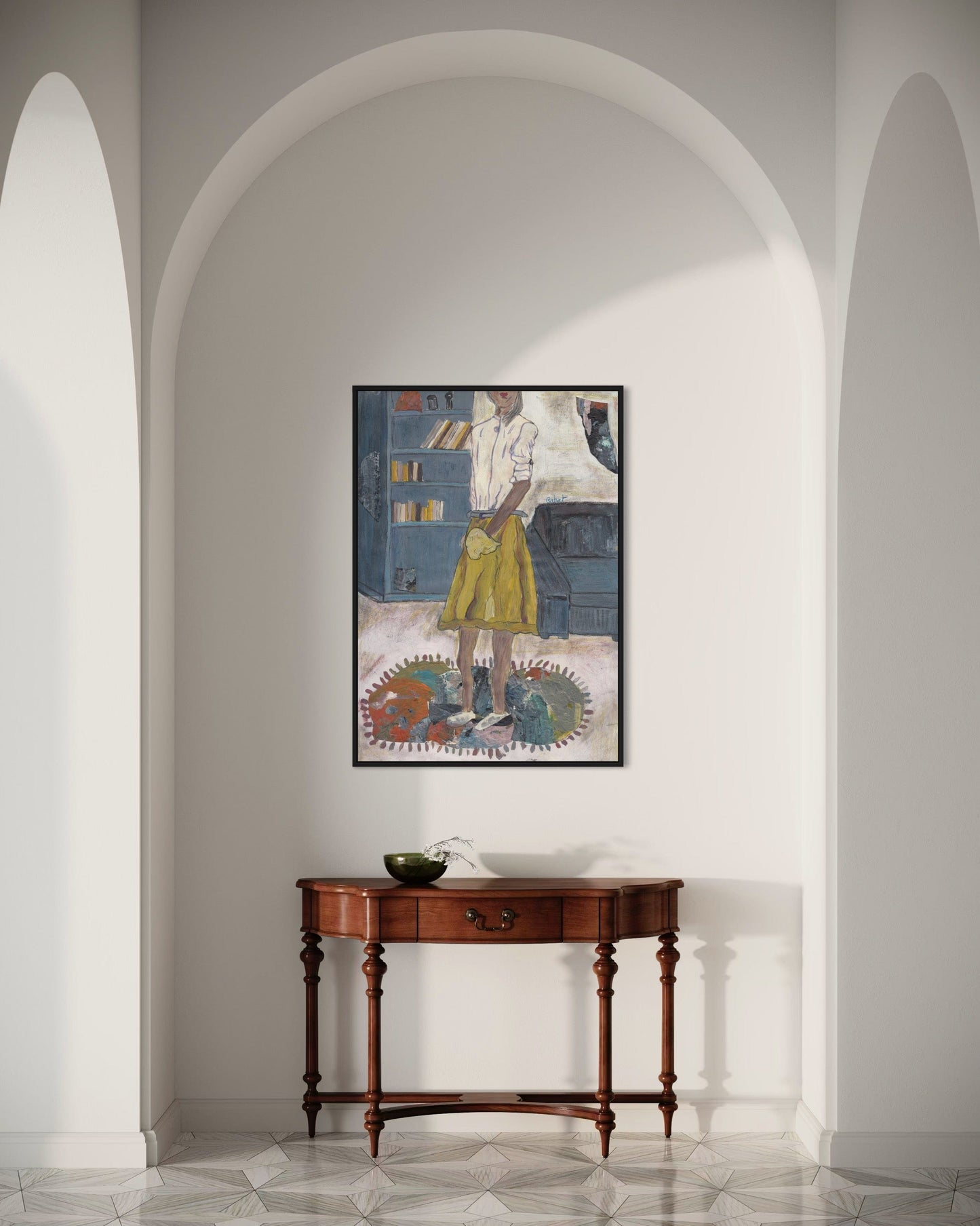 Framed artwork on a wall above a wooden console table in a room with arched doorways.