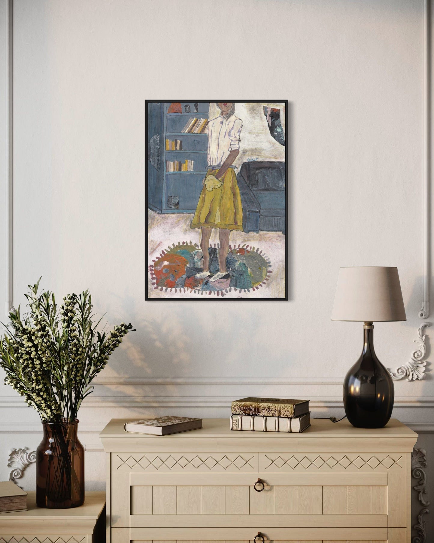 Framed artwork on a wall above a wooden cabinet with decorative items.