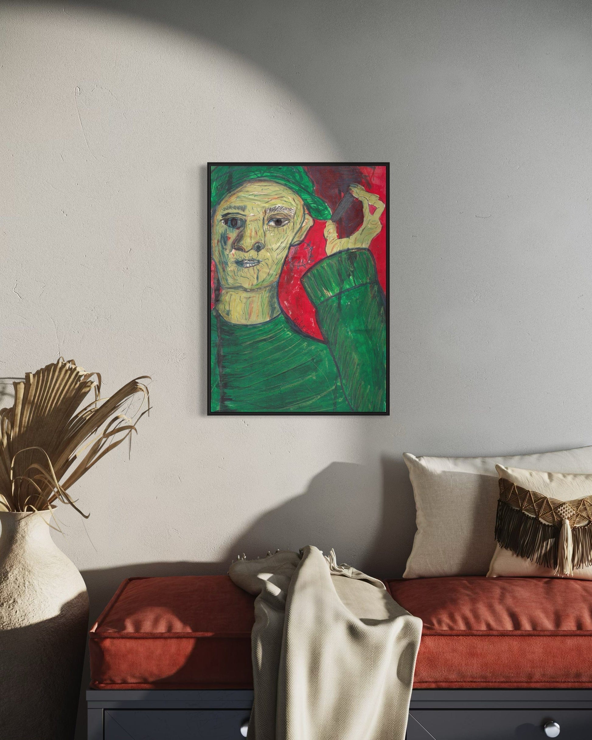 Framed artwork of a stylized portrait on a wall above a sofa in a living room.