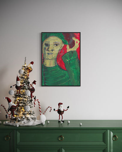 Decorative Christmas tree with ornaments on a green cabinet against a wall with a framed painting.