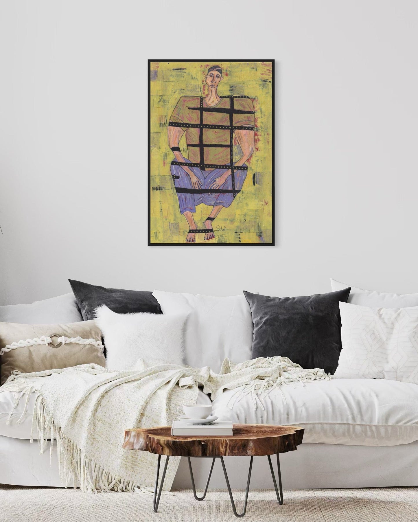 Living room with a white sofa, wooden coffee table, and abstract art on the wall.