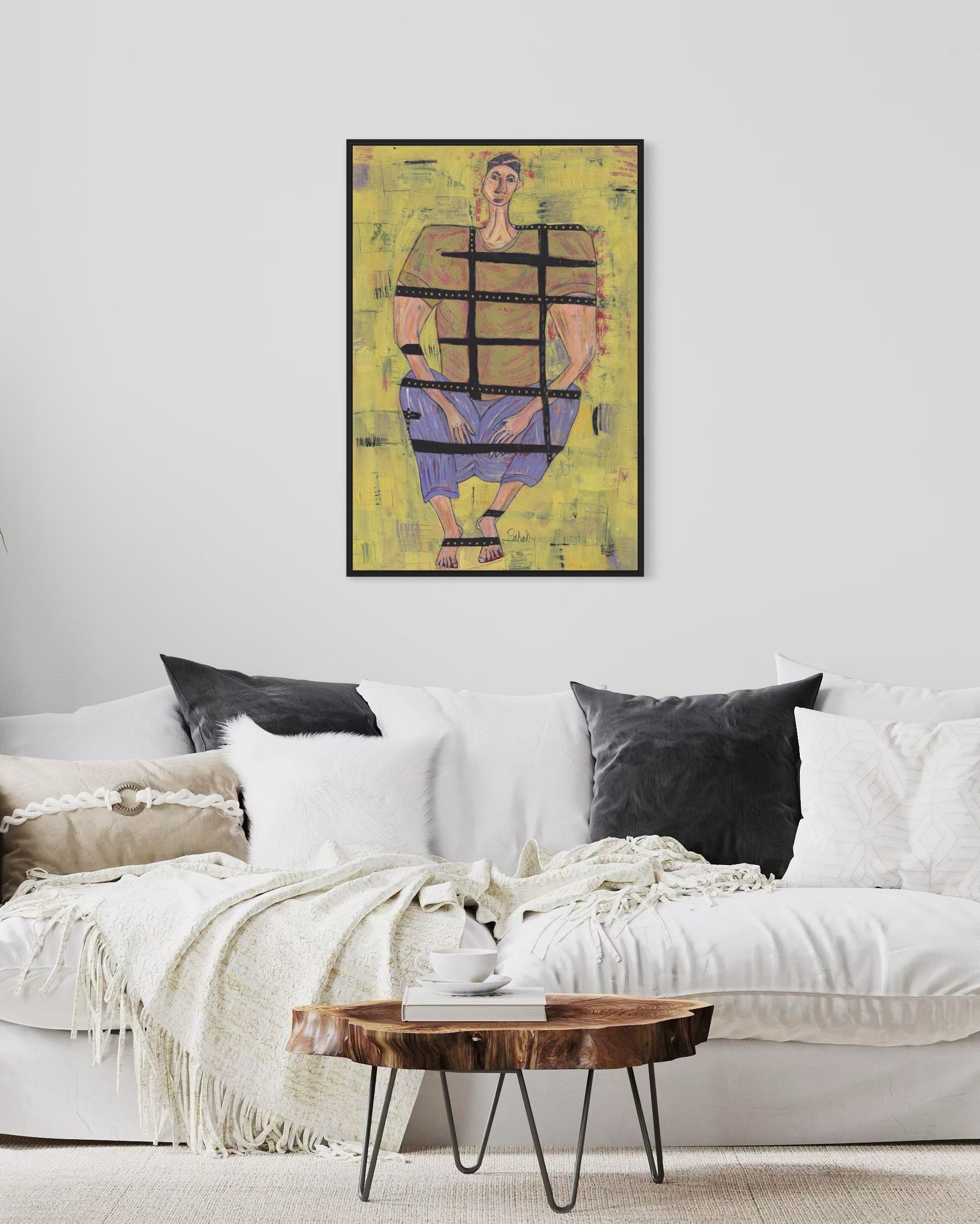 Living room with a white sofa, wooden coffee table, and abstract art on the wall.