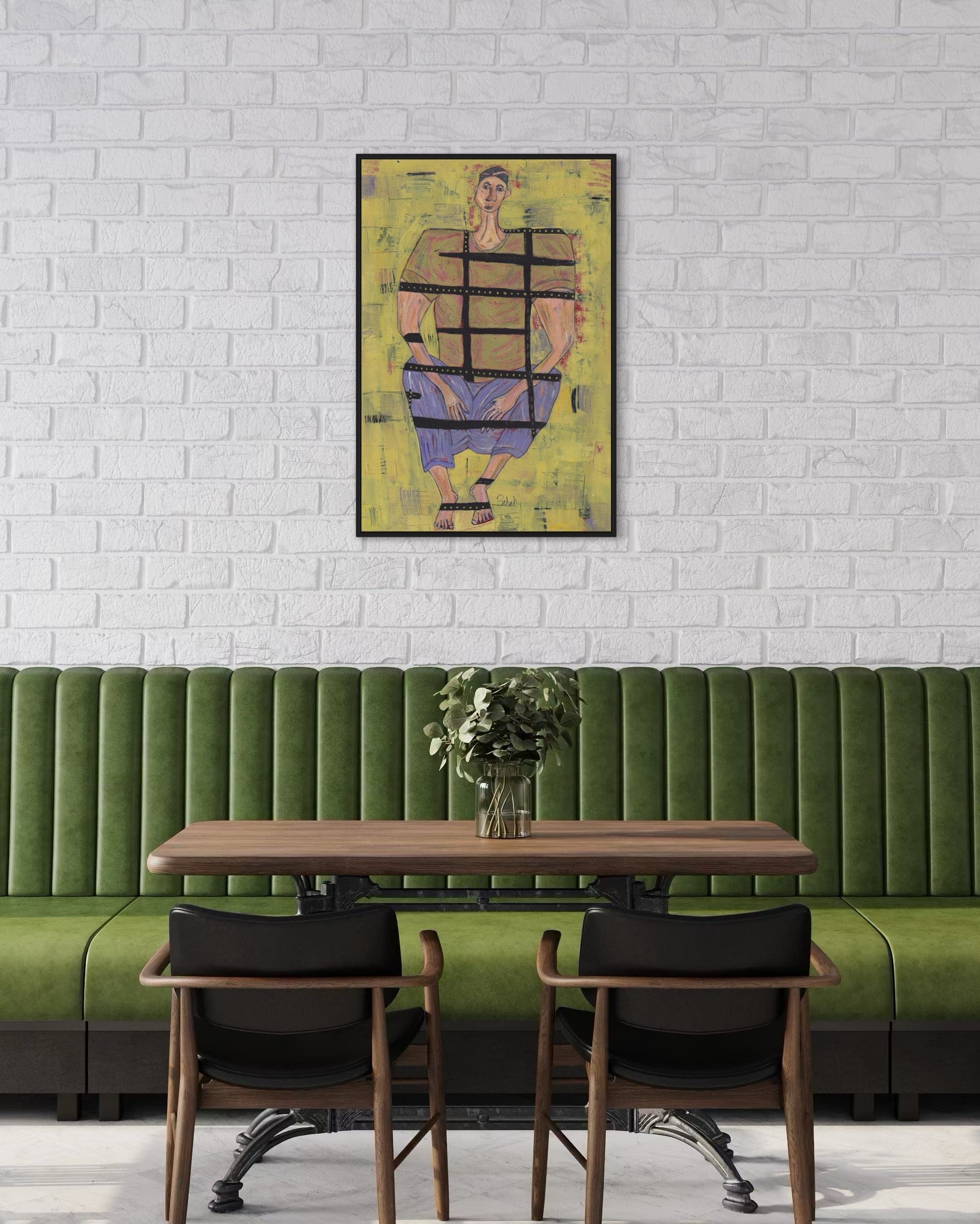 Green booth with wooden table and chairs against a white brick wall with a colorful abstract painting.