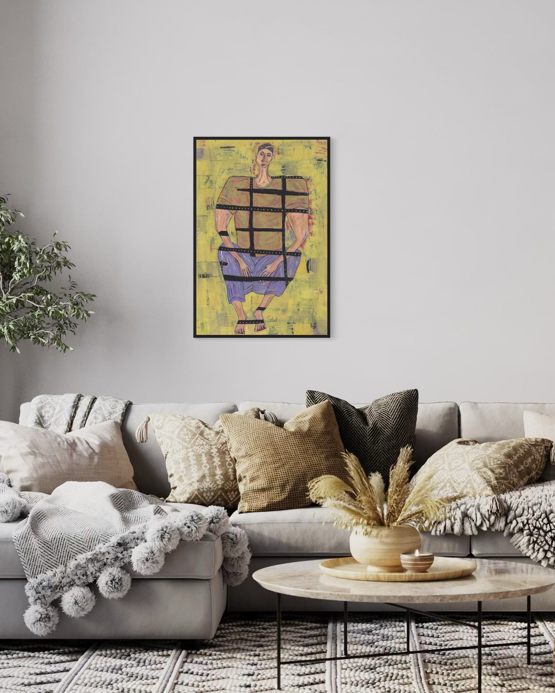 Living room with a gray sofa, decorative pillows, and a framed artwork on the wall.