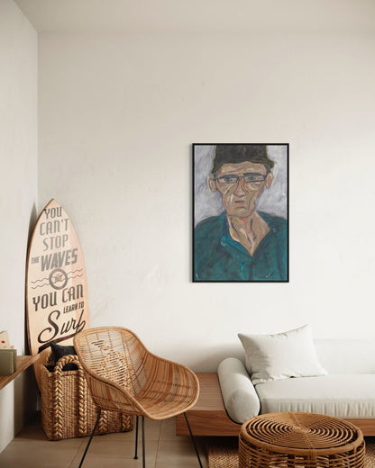 Living room with a surfboard, wicker chair, and framed portrait on the wall.