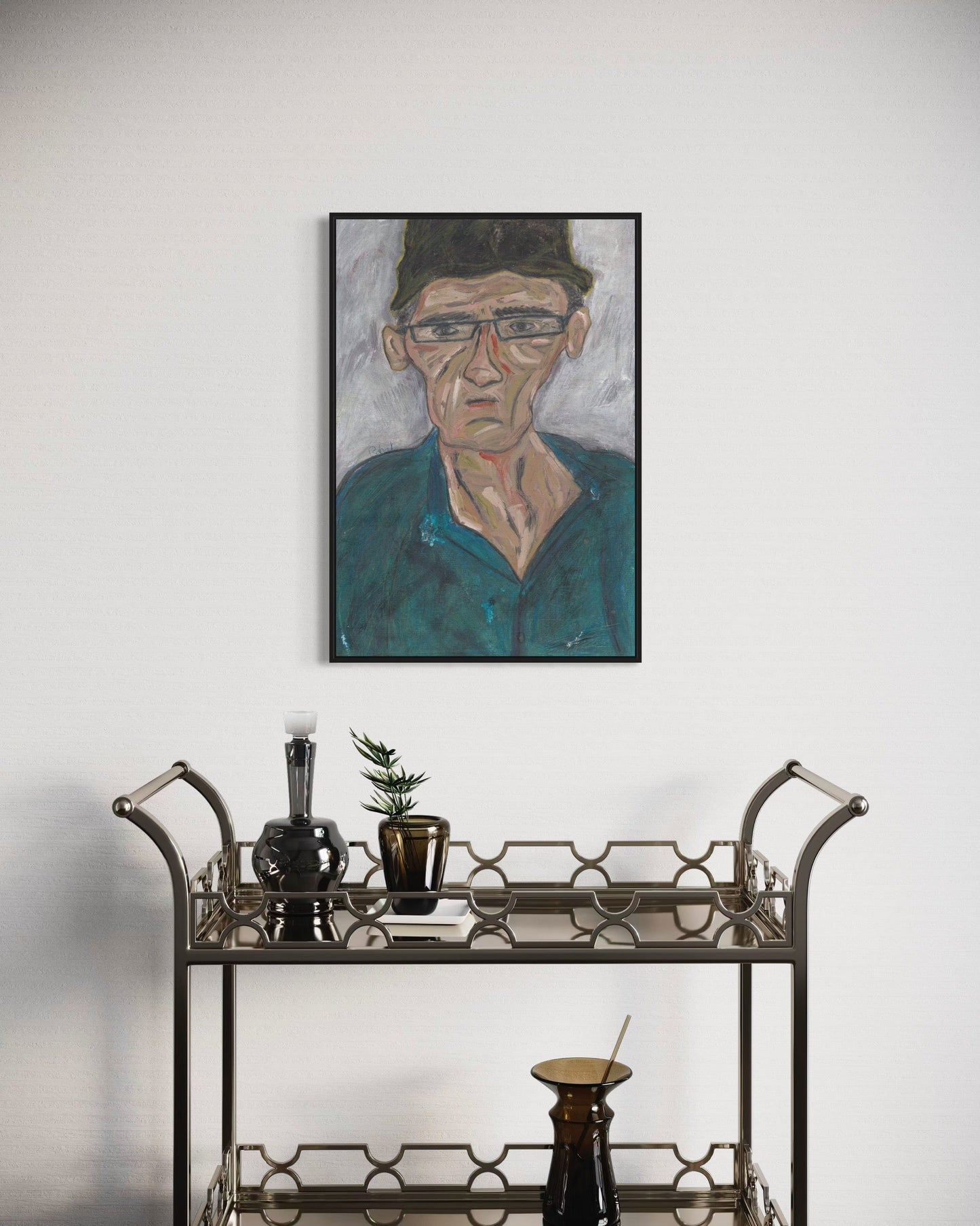 Framed portrait of a man above a bar cart with decorative items.