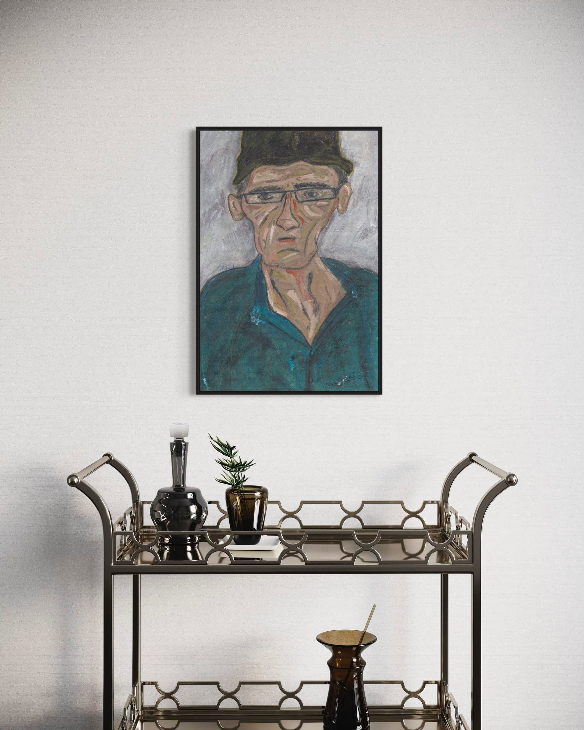Framed portrait of a man above a bar cart with decorative items.