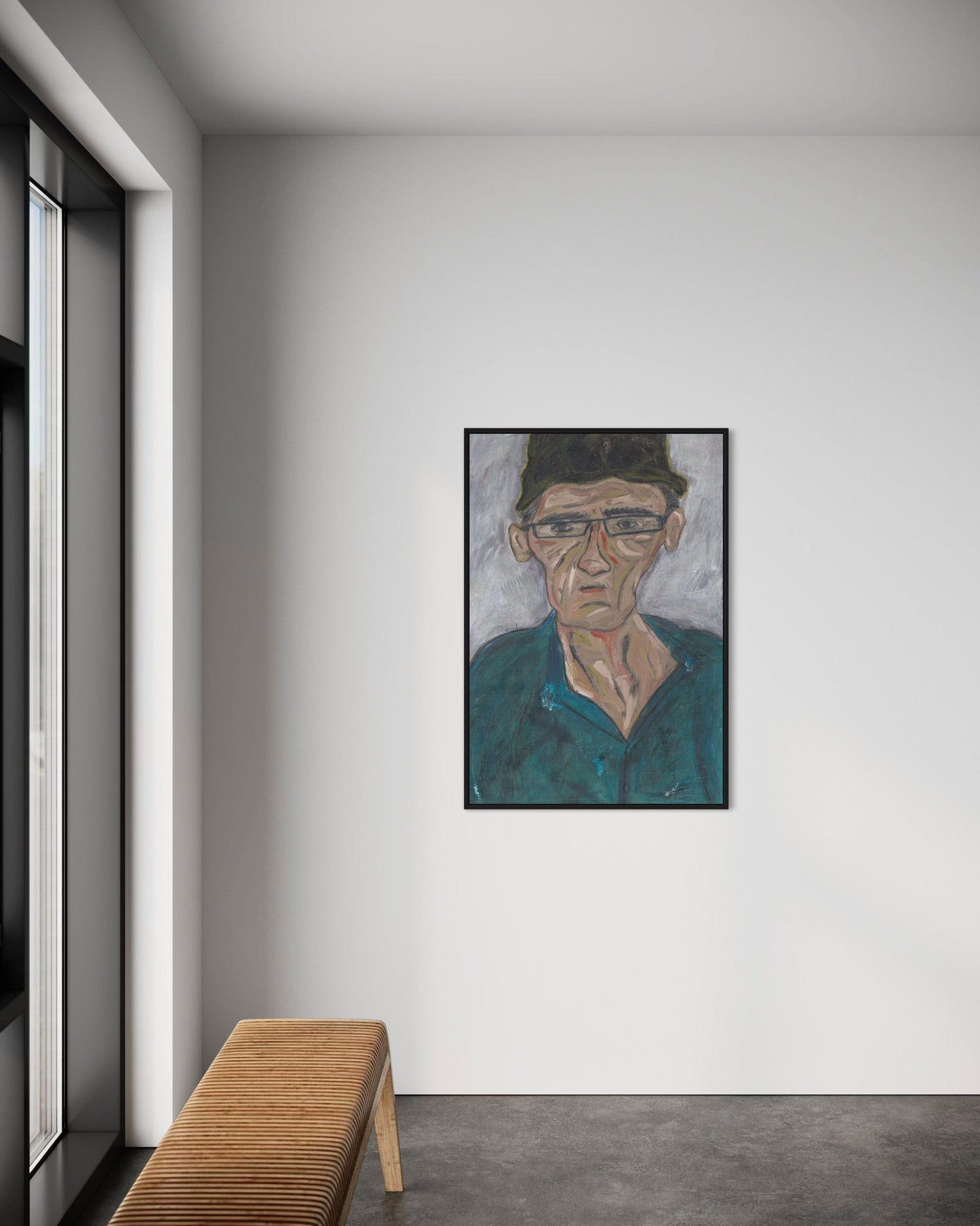 Framed portrait on a wall in a modern interior setting with a wooden bench.