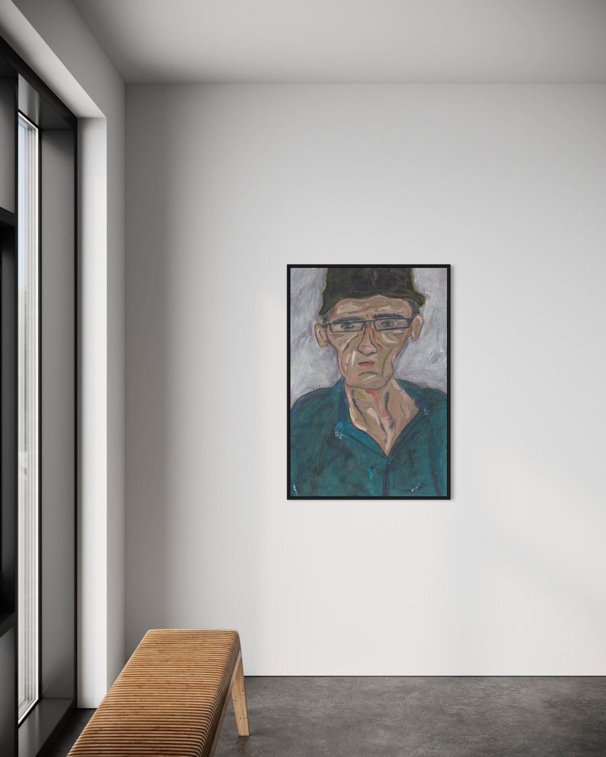 Framed portrait on a wall in a modern interior setting with a wooden bench.
