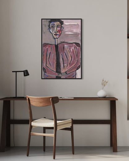 Artistic portrait on a wall above a wooden desk with a chair.