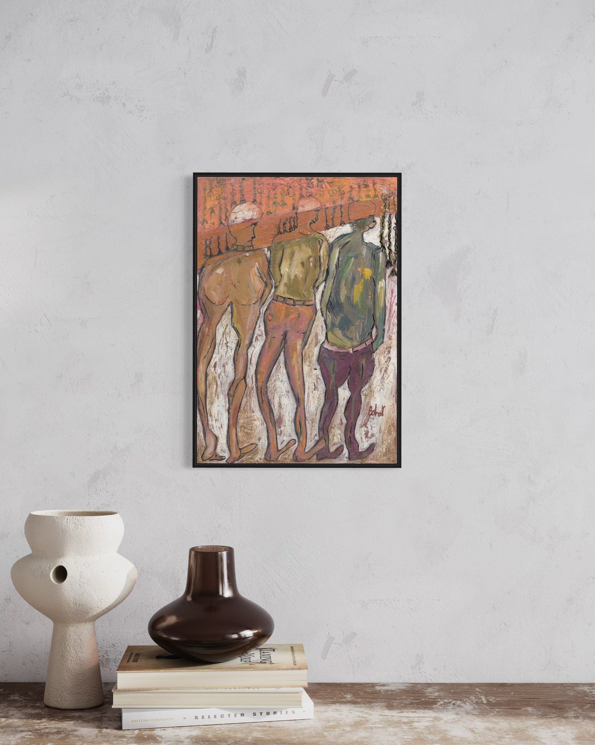 Framed artwork of three figures on a wall above decorative vases and books.