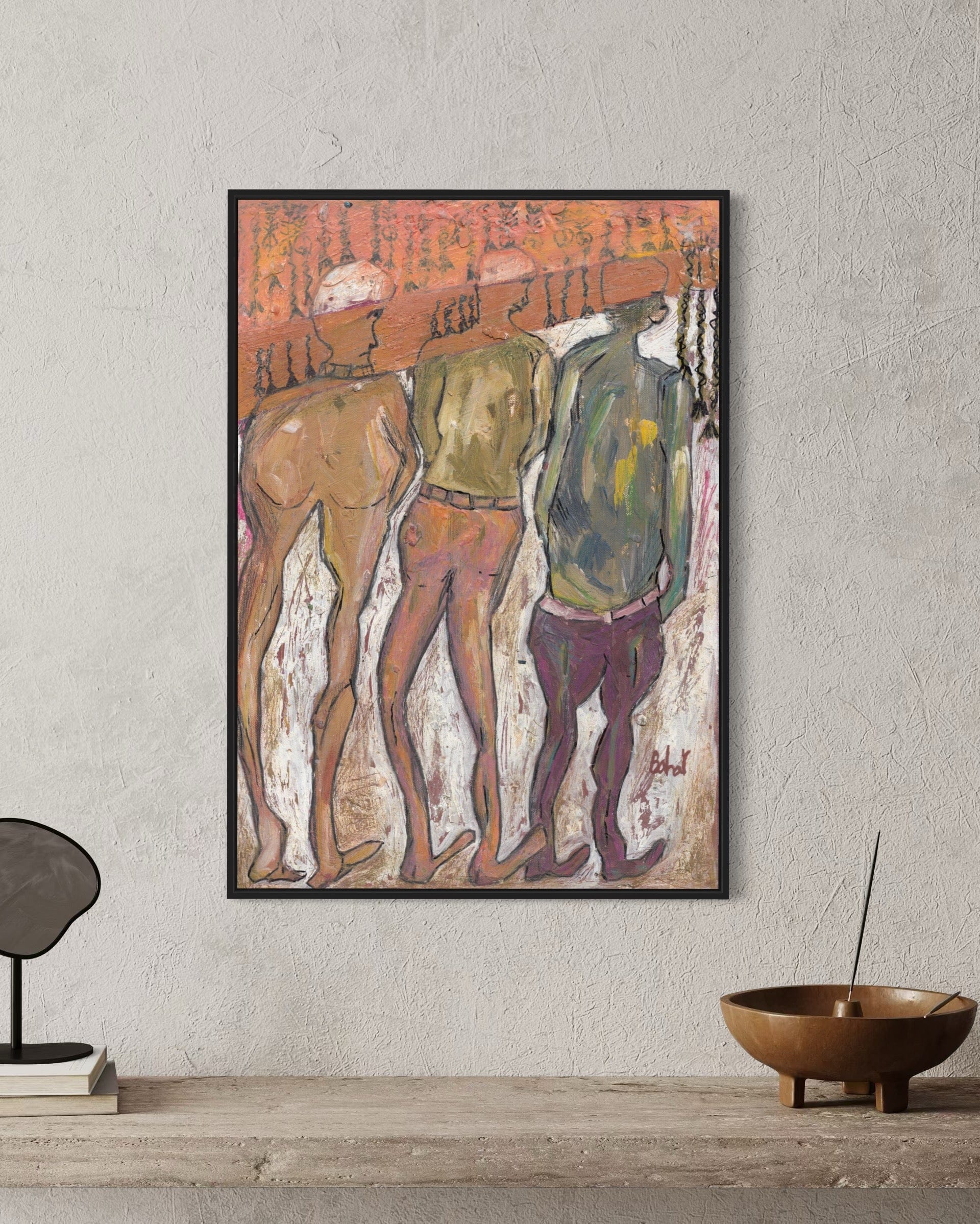 Framed artwork of three figures on a textured wall with minimal decor.