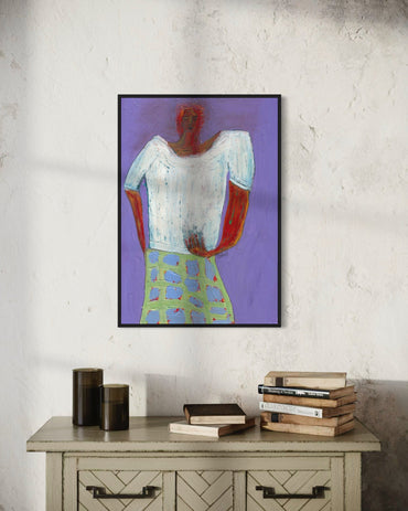 Framed abstract art on a wall above a wooden cabinet with books.