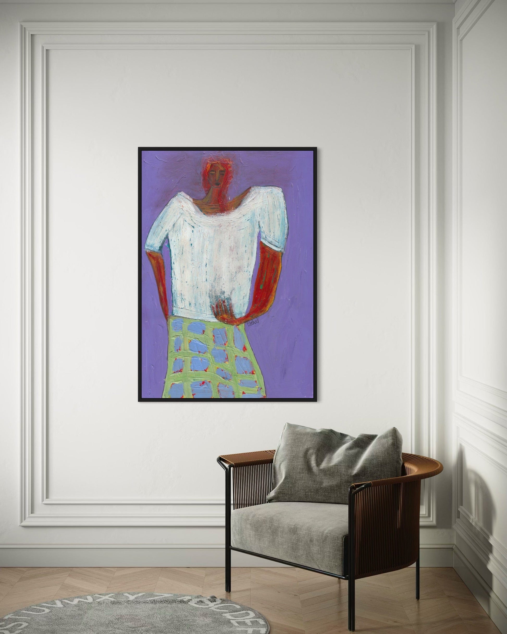 Framed abstract painting on a wall above a chair with a gray cushion.