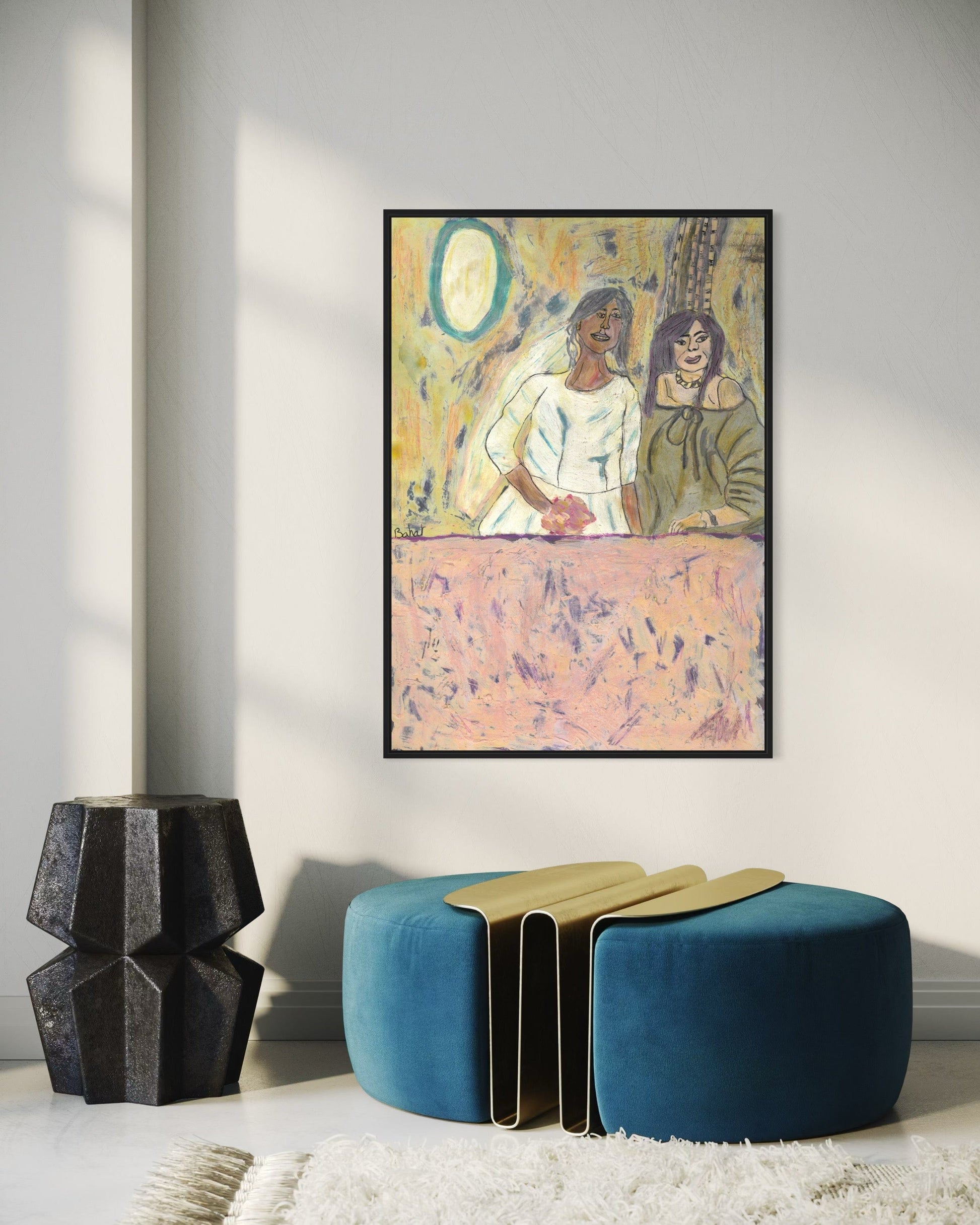 Framed abstract artwork on a wall with a blue ottoman and decorative vase below.