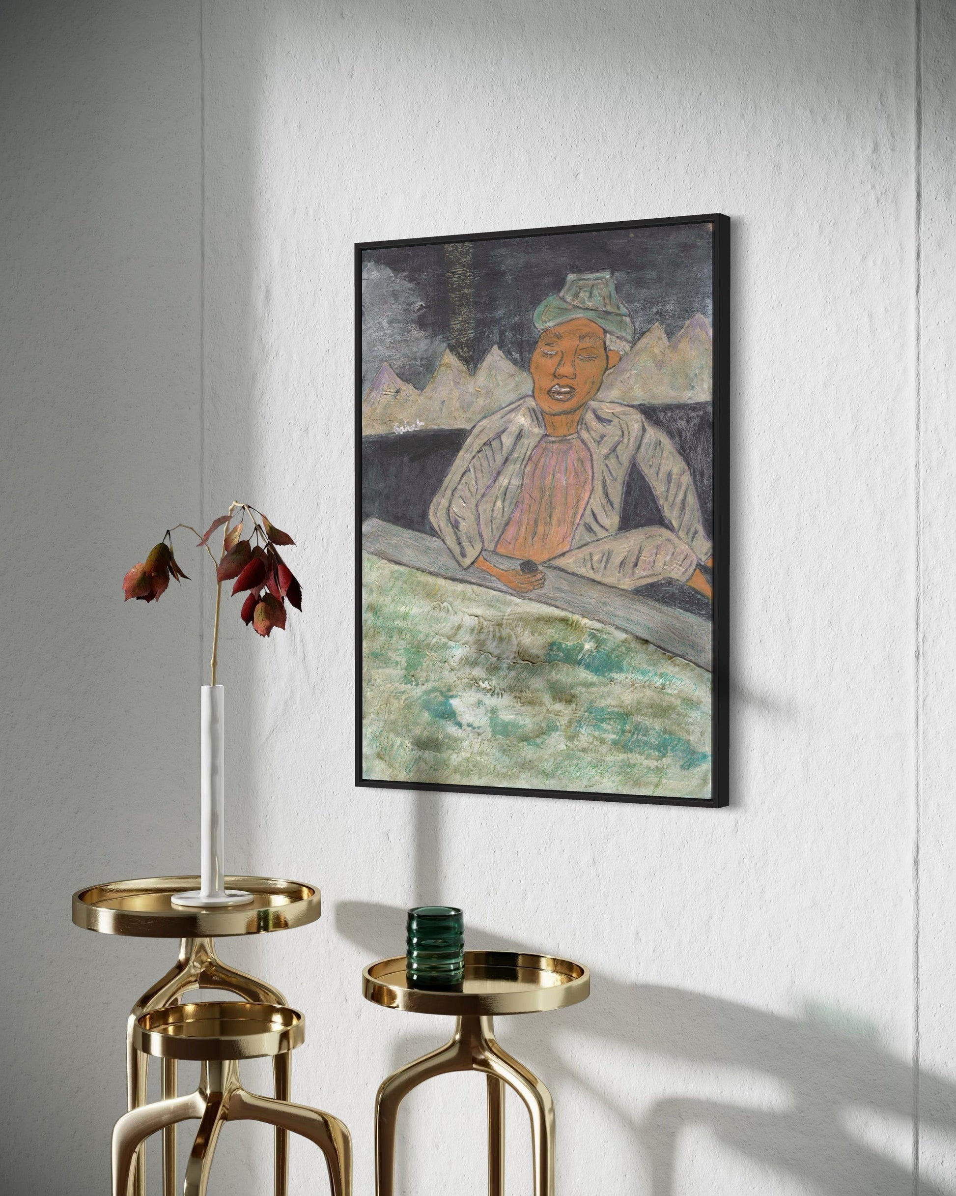 Framed artwork on a wall with gold side tables below