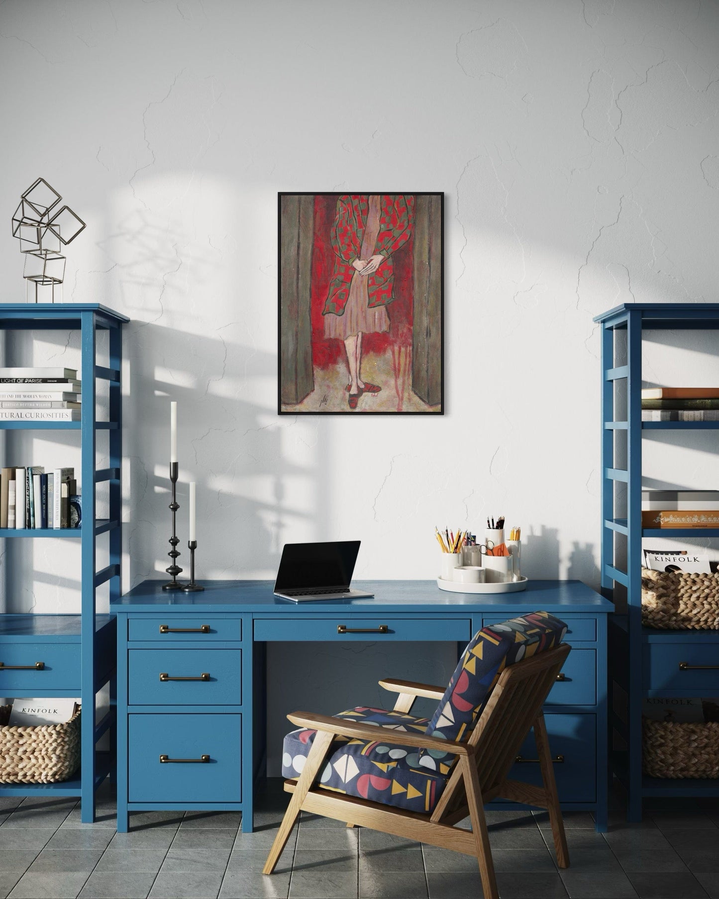 Home office with blue desk, chair, and bookshelves, featuring a painting on the wall.